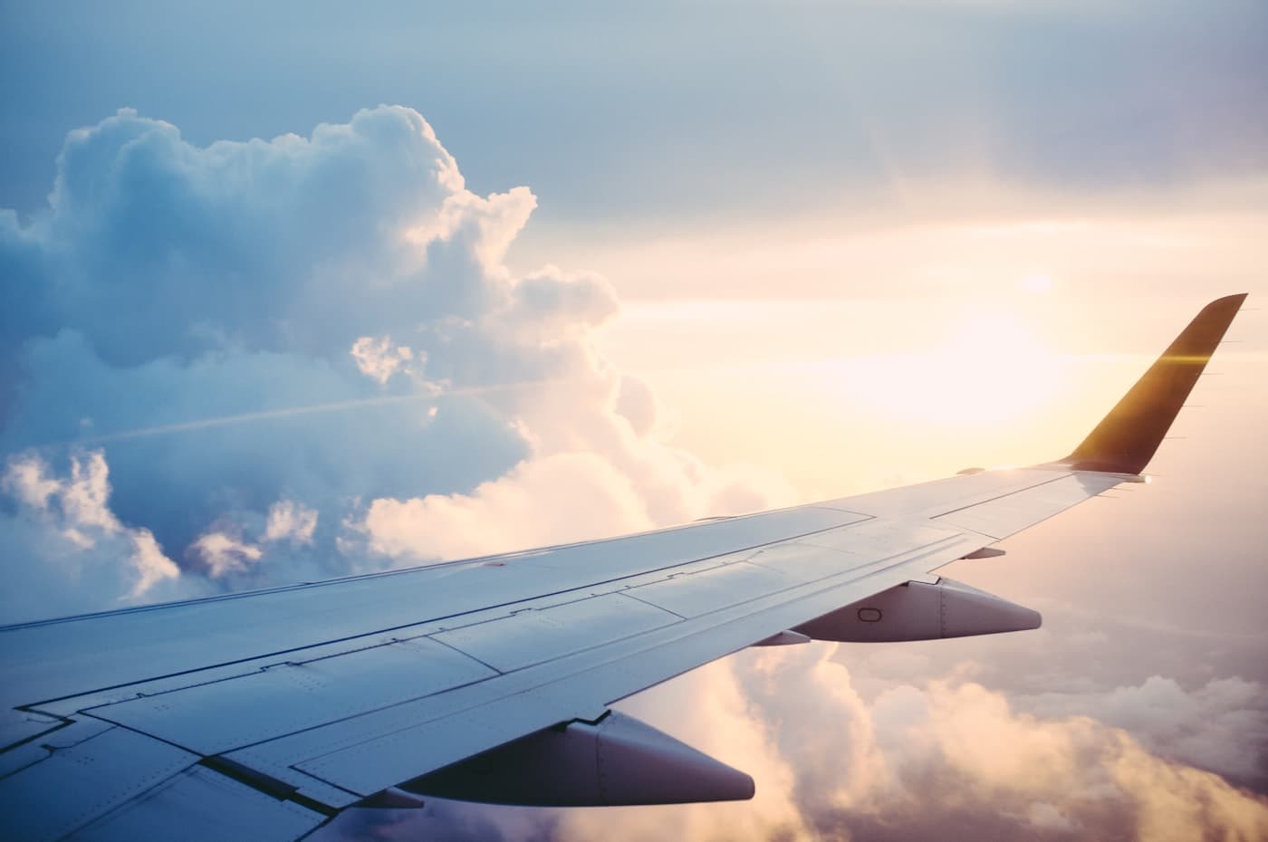 Aircraft wing over clouds for airport transfer service